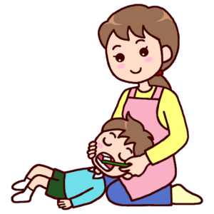 Parent brushing her child's teeth with a toothbrush, child lying down and smiling